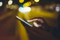 Girl pointing finger on screen smartphone on background illumination glow bokeh light in night atmospheric city, hipster using Royalty Free Stock Photo