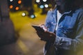 Girl pointing finger on screen smartphone on background illumination glow bokeh light in night atmospheric city, hipster using Royalty Free Stock Photo