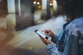 Girl pointing finger on screen smartphone on background illumination glow bokeh light in night atmospheric city, hipster using Royalty Free Stock Photo