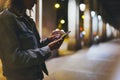 Girl pointing finger on screen smartphone on background illumination glow bokeh light in night atmospheric city, hipster using Royalty Free Stock Photo