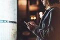 Girl pointing finger on screen smartphone on background light box in night atmospheric city map, hipster using in female hands and Royalty Free Stock Photo