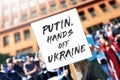 Girl with political banner Message Putin,hands off Ukraine at protest rally. Reportageeditorial photo for the war between Russia a