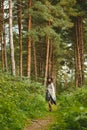 A girl in a poncho and a hat in forest