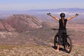 GIRL WITH PONYTAIL ON A MOUNTAIN BIKE ON THE TOP OF A MOUNTAIN WITH OPEN ARMS Royalty Free Stock Photo