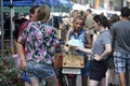 Girl with a ponytail, wearing shorts, with a small dog to hang out with her friends on Saturday Broadway Market