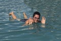 Girl in the pool outdoors. The salt water of the pool holds it on the surface of the water. Smiling, sunglasses on his head