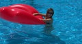 Girl in the pool with a red mattress in the form of lips