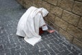 A girl in poor clothes sits on the ground Royalty Free Stock Photo