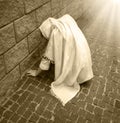 A girl in poor clothes sits on the ground Royalty Free Stock Photo