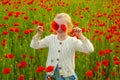 Girl with poppies eyes. Poppies meadow with poppys flowers. Beautiful child girl walking in spring poppy flower field Royalty Free Stock Photo