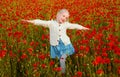 Girl in poppies, happiness and freedom, beautiful spring nature. Happy kid resting on a beautiful poppy field. Child Royalty Free Stock Photo