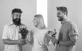 Girl popular receive lot men attention. Woman smiling can not choose partner, grabs both bouquets. Men competitors with Royalty Free Stock Photo