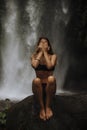 A girl poses in a bikini in a waterfall in a forest Royalty Free Stock Photo