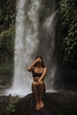 A girl poses in a bikini in a waterfall in a forest Royalty Free Stock Photo