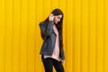 A girl posing against a yellow building background