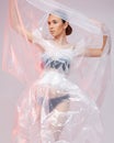 Girl posing in a dress made of plastic film. Fashion portrait.