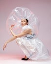 Girl posing in a dress made of plastic film. Fashion portrait.