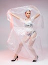 Girl posing in a dress made of plastic film. Fashion portrait.