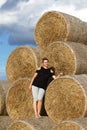 Girl posing near a stack of straw. Straw rolls, stacked in a pyramid Royalty Free Stock Photo