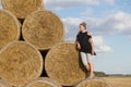 Girl posing near a stack of straw. Straw rolls, stacked in a pyramid Royalty Free Stock Photo