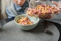 Girl pouring corn flakes into the plate while preparing breakfast Royalty Free Stock Photo