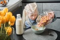 Girl pouring corn flakes into the plate while preparing breakfast Royalty Free Stock Photo