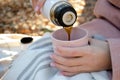 The girl pours hot coffee from a thermos into a cup. Royalty Free Stock Photo