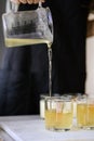 The girl pours wax into glass glasses with wicks. Royalty Free Stock Photo