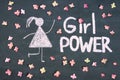 GIRL POWER chalk written message and woman drawing symbol on chalkboard or blackboard. Live pink flowers around. Lettering text s