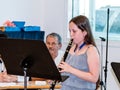 Girl practicing flute playing at a lesson in the music class in