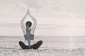 Girl is practicing yoga on the beach. Back view, black and white Royalty Free Stock Photo