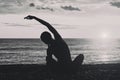 Girl practicing yoga on the beach. View from the back, silhouettes. Black and white Royalty Free Stock Photo