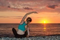 Girl practicing yoga on the beach. View from the back, sunset Royalty Free Stock Photo