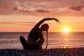 Girl practicing yoga on the beach. View from the back, sunset Royalty Free Stock Photo