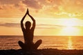 Girl is practicing yoga on the beach. View from the back, sunset Royalty Free Stock Photo