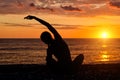 Girl practicing yoga on the beach. View from the back, sunset, s Royalty Free Stock Photo