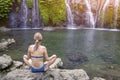 Girl practicing yoga and meditating in lotus position in nature Royalty Free Stock Photo