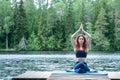 Girl practicing yoga in the nature on the lake. Female happiness. Landscape background, space for text Royalty Free Stock Photo