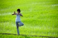 Girl practicing yoga,standing in paddy field