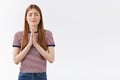 Girl praying god, have faith dreams come true if believe. Attractive fair-haired woman in striped t-shirt clasp palms Royalty Free Stock Photo