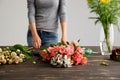 Girl prepare to make bouquet over gray background. Royalty Free Stock Photo