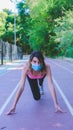 A girl prepared to run on a running track with the mask to avoid the Covid virus 19