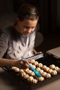 A girl prepares a dish of a pig in a blanket