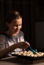 A girl prepares a dish of a pig in a blanket