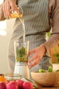 Girl is preparing a green smoothie in a blender Royalty Free Stock Photo