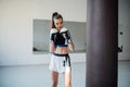 The girl is preparing for a boxing competition and trains punches on a punching bag in a spacious gym Royalty Free Stock Photo