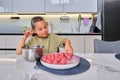 A girl is preparing meatballs in the kitchen.