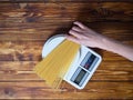 Girl is preparing pasta and weighs it on scales