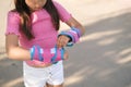 Girl is preparing for roller skating, wearing protective gloves