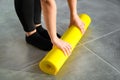 Girl is preparing to unwrap yellow roll of sports mat for fitness. Hands are lying on mat, close-up.